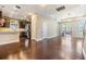 Open-concept living area with dark wood floors connecting the kitchen and patio at 19400 Roseate Dr, Lutz, FL 33558