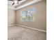 Light filled main bedroom with carpet and view of the screened pool through the window at 19400 Roseate Dr, Lutz, FL 33558