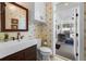 A powder room with patterned wallpaper, a white vanity sink, and an outdoor view from the open door at 2303 S Occident St, Tampa, FL 33629