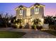 Stunning two-story home with brick paved driveway, lush landscaping, and illuminated exterior at 2303 S Occident St, Tampa, FL 33629