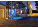 The exterior shows a screened pool with vibrant lighting and a covered patio with furniture at 2303 S Occident St, Tampa, FL 33629