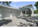Exterior of a two-story home featuring a screened-in pool, a two-car garage, and a paver driveway at 2303 S Occident St, Tampa, FL 33629
