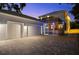 Exterior of a two-story home featuring a screened-in pool, a two-car garage, and a paver driveway at 2303 S Occident St, Tampa, FL 33629