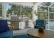 Covered lanai featuring a stainless steel grill, comfortable seating, and an overhead ceiling fan at 2303 S Occident St, Tampa, FL 33629