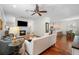 Open concept living room with fireplace and wood floors flows into kitchen with stainless steel appliances and breakfast bar at 2303 S Occident St, Tampa, FL 33629