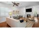 Bright living room with white walls, fireplace, ceiling fan and wood floors provides a warm, inviting atmosphere at 2303 S Occident St, Tampa, FL 33629