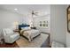 Main bedroom with a ceiling fan, wood floor, two windows, and a floral bed set at 2303 S Occident St, Tampa, FL 33629