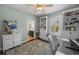 Light office with blue accent rug, built-in shelving, desk, ceiling fan, and adjacent bathroom at 2303 S Occident St, Tampa, FL 33629