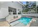 Beautiful pool area with travertine tile and covered seating area perfect for outdoor relaxation at 2303 S Occident St, Tampa, FL 33629
