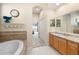 Bathroom with tub, granite countertop, and an arched entry to the main bedroom at 2402 Blue Stone Ct, Valrico, FL 33594