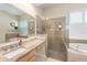 Bathroom showcasing a granite countertop, framed glass shower, and soaking tub at 2402 Blue Stone Ct, Valrico, FL 33594