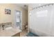Bathroom features a granite countertop vanity, white shower curtain and a door to the outdoors at 2402 Blue Stone Ct, Valrico, FL 33594