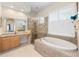 Bathroom featuring soaking tub, walk-in shower and lots of natural light at 2402 Blue Stone Ct, Valrico, FL 33594