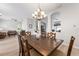 Open-concept dining room with wood table and chandelier, seamlessly connects to the living room and other living spaces at 2402 Blue Stone Ct, Valrico, FL 33594