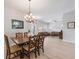 Open concept dining room boasts a chandelier and light wood floors adjacent to a living area with comfortable seating at 2402 Blue Stone Ct, Valrico, FL 33594