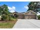 Beautiful home showcasing a two-car garage, stone accents, and lush landscaping in a serene setting at 2402 Blue Stone Ct, Valrico, FL 33594