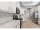 Modern kitchen with sleek white cabinetry, marble countertops, stainless steel appliances, and mosaic backsplash at 2402 Blue Stone Ct, Valrico, FL 33594