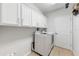 Well-organized laundry room features a modern washer and dryer set and white cabinets for ample storage space at 2402 Blue Stone Ct, Valrico, FL 33594
