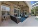 Covered patio featuring a ceiling fan and stylish seating area with a rug, perfect for outdoor relaxation at 2402 Blue Stone Ct, Valrico, FL 33594