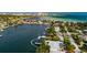 Aerial view of the home on a waterfront canal with a boat dock, surrounded by lush tropical landscaping and other houses at 2487 W Bay Isle Se Dr, St Petersburg, FL 33705