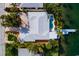 Aerial view showcases a backyard pool, patio, and private dock extending into the waterway at 2487 W Bay Isle Se Dr, St Petersburg, FL 33705