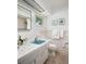 Bright bathroom features a blue sink, tiled walls, and a window offering natural light at 2487 W Bay Isle Se Dr, St Petersburg, FL 33705