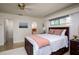 Cozy bedroom with a ceiling fan, large window, and comfortable-looking bed with pink accents at 2487 W Bay Isle Se Dr, St Petersburg, FL 33705
