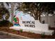 A view of the community sign for Tropical Shores, set amongst manicured landscaping at 2487 W Bay Isle Se Dr, St Petersburg, FL 33705
