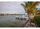 Scenic waterfront view featuring a dock, lush palm trees, and sailboats on the water at 2487 W Bay Isle Se Dr, St Petersburg, FL 33705