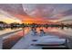 Waterfront home featuring a private dock with seating and boat storage under a beautiful sunset sky at 2487 W Bay Isle Se Dr, St Petersburg, FL 33705