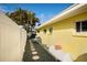 View of the side exterior featuring a walkway, gravel, and home's architectural details at 2487 W Bay Isle Se Dr, St Petersburg, FL 33705