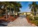 Well-maintained home with lush landscaping, mature palm trees, and a brick paver driveway at 2487 W Bay Isle Se Dr, St Petersburg, FL 33705