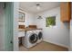 Functional laundry room with washer, dryer, utility sink, and natural light from a window at 2487 W Bay Isle Se Dr, St Petersburg, FL 33705