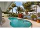 Inviting backyard pool and jacuzzi surrounded by lush tropical landscaping with waterfront views at 2487 W Bay Isle Se Dr, St Petersburg, FL 33705