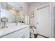 Bright bathroom features a modern vanity, white cabinets, quartz counters, and decorative floral accents at 2653 Longleaf Pine Pt, New Port Richey, FL 34655