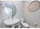 Powder room with pedestal sink, modern fixtures, decorative mirror and artwork, and sleek toilet at 2653 Longleaf Pine Pt, New Port Richey, FL 34655