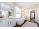 Luxurious bathroom showcasing a freestanding tub, dual vanities, and wood-look tile flooring at 2653 Longleaf Pine Pt, New Port Richey, FL 34655