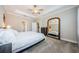 Spacious bedroom featuring a plush carpet, ceiling fan, and a large mirror at 2653 Longleaf Pine Pt, New Port Richey, FL 34655