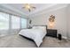 Comfortable bedroom with tray ceiling, ceiling fan, and natural light from large windows at 2653 Longleaf Pine Pt, New Port Richey, FL 34655