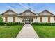 Inviting clubhouse entrance with a charming walkway, well-maintained landscaping, and a welcoming facade at 2653 Longleaf Pine Pt, New Port Richey, FL 34655