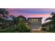 Charming home featuring stone accents, manicured landscaping, brick paved driveway, and a two-car garage under a colorful sky at 2653 Longleaf Pine Pt, New Port Richey, FL 34655