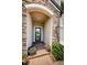Charming front entrance with stone details, a welcoming wreath, and vibrant floral arrangements at 2653 Longleaf Pine Pt, New Port Richey, FL 34655
