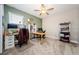 Inviting home office featuring large windows, ceiling fan, and ample space for multiple workstations at 2653 Longleaf Pine Pt, New Port Richey, FL 34655