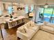 Open-concept living space with a kitchen island, dining area, and comfortable seating, with a view to the pool at 2653 Longleaf Pine Pt, New Port Richey, FL 34655
