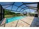 Inviting pool area with screened enclosure, lounge chairs, and scenic views of the pond at 2653 Longleaf Pine Pt, New Port Richey, FL 34655