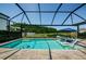 Sparkling pool featuring a screened enclosure, lounge chairs, and a serene view of the pond at 2653 Longleaf Pine Pt, New Port Richey, FL 34655