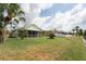 Expansive backyard with a screened-in porch, lush lawn, and partial fence for privacy at 29542 Forest Glen Dr, Wesley Chapel, FL 33543