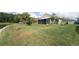 Large backyard featuring a lush lawn, mature landscaping, and partial view of a retention pond at 29542 Forest Glen Dr, Wesley Chapel, FL 33543