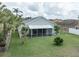 Spacious backyard with lush green lawn, a screened lanai, and mature landscaping at 29542 Forest Glen Dr, Wesley Chapel, FL 33543