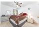 Comfortable bedroom features queen size bed, ceiling fan, dresser with mirror, and side table with lamp at 29542 Forest Glen Dr, Wesley Chapel, FL 33543